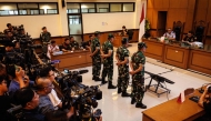 Four Indonesian military personnel accused of throwing acid at a human rights activist attend a verdict hearing at a military court in Jakarta on June 10, 2026. (Photo by Yasuyoshi Chiba / AFP)