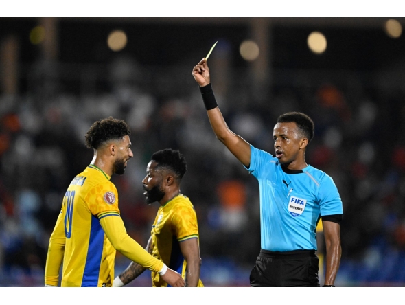 Gabon's forward #20 Denis Bouanga is shown the yellow card by Somali referee Omar Abdulkadir Artan during the Africa Cup of Nations (CAN) Group F football match between Gabon and Ivory Coast at the Grand Stadium in Marrakech on December 31, 2025. Photo by KHALED DESOUKI / AFP