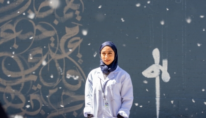 Fatima Alsharshani in front of her mural in Montreal.