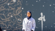 Fatima Alsharshani in front of her mural in Montreal.