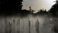 People off in a water fountain as Spain experiences a heatwave, in Madrid. (Photo by Oscar Del Pozo / AFP)