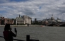 A woman takes a photo toward St. Paul's from the south side of the River Thames in central London on June 28, 2026, as people come out to take advantage of cooler temperatures following days of extreme heat. The UK broke the record for a June temperature for the third day in a row on June 26, the Met Office weather agency said, as a sweltering heatwave strained schools and hospitals and drove down business. (Photo by CARLOS JASSO / AFP)