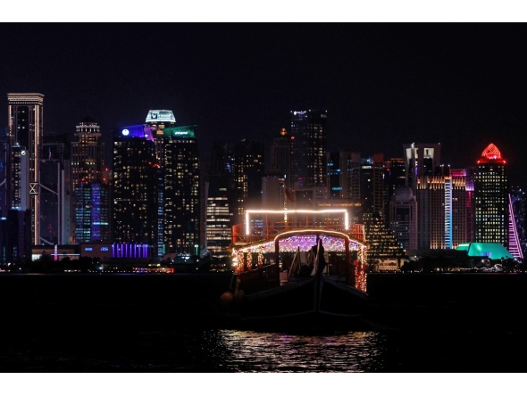 Illuminated skyscrapers are pictured along the corniche promenade in Doha on June 29, 2026. (Photo by Karim Jaafar / AFP)
