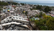 This aerial view taken on July 2, 2026, in Caraballeda in the state of La Guaira shows collapsed buildings following the June 24 twin earthquakes. (Photo by Miguel Medina / Pool / AFP)