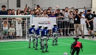 Spectators watch robots taking part in a football match at RoboCup 2026, a robotics and Artificial Intelligence (AI) competition in Incheon on July 3, 2026. (Photo by Jade Gao / AFP)