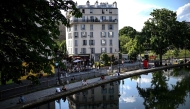 Files: People sit along the canal Saint-Martin in Paris on May 17, 2022. Photo by Christophe Archambault / AFP