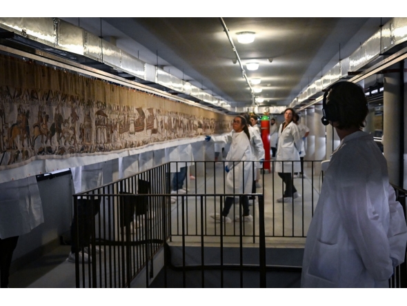 Workers and volunteers, rest before preparing to pack the Bayeux Tapestry in a crate for transfer to the British Museum, at the Bayeux Tapestry Museum, in Bayeux, northwestern France, on September 18, 2025. Photo by Lou Benoist / Pool / AFP