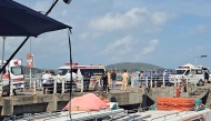 Ambulances line up on a pier to help victims of a boating accident after a tourist vessel capsized off Phu Quoc Island in southern Vietnam's An Giang Province on July 11, 2026. At least 15 people were killed when a tourist boat capsized off an island in Vietnam's south, state media reported on July 11. (Photo by AFP)