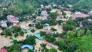 This aerial photograph shows partially submerged residential buildings following heavy rains in Bangladesh's Bandarban town on July 11, 2026. (Photo by Syed Amir Hosain Masum / AFP)