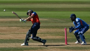 England's Jos Buttler hits a boundary as India's Sanju Samson keeps wicket during the fifth Twenty20 (T20) International cricket match between England and India at Utilita Bowl in Southampton on July 11, 2026. (Photo by JUSTIN TALLIS / AFP)
