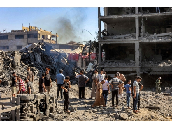 People gather by the rubble of destroyed buildings following an Israeli strike on an industrial area in Gaza City on July 12, 2026. (Photo by Omar Al-Qattaa / AFP)