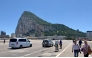 The Rock of Gibraltar is seen in the background as people and cars cross over the Gibraltar airport runway after crossing the border between Spain and the British territory of Gibraltar on May 5, 2022. (Photo by Daniel SLIM / AFP)
