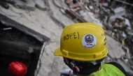 Volunteers and Mexican rescuers search for bodies amid debris of buildings damaged by the June 24 earthquakes, in Tanaguarena, state of La Guaira; Venezuela, on July 18, 2026. (Photo by Juan Barreto / AFP)