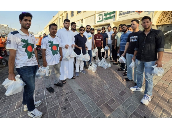 Volunteers from Qatar Probashi Bondhushava distribute refreshments among delivery riders.