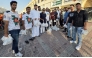 Volunteers from Qatar Probashi Bondhushava distribute refreshments among delivery riders.