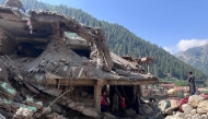 Afghan men search the debris of destroyed shops after flash floods hit Parun town in Afghanistan's Nuristan province, on July 21, 2026. (Photo by AFP)