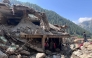 Afghan men search the debris of destroyed shops after flash floods hit Parun town in Afghanistan's Nuristan province, on July 21, 2026. (Photo by AFP)