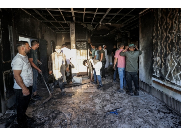 Palestinians watch as a fire blazes near the village of Tell, west of Nablus in the occupied West Bank on July 18, 2026, after a reported arson attack by Israeli settlers on the village, according to eyewitnesses. Photo by JAAFAR ASHTIYEH / AFP