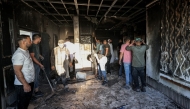 Palestinians watch as a fire blazes near the village of Tell, west of Nablus in the occupied West Bank on July 18, 2026, after a reported arson attack by Israeli settlers on the village, according to eyewitnesses. Photo by JAAFAR ASHTIYEH / AFP