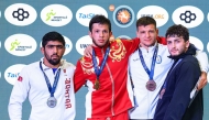 Qatar wrestler Shahin Eidimohammad Badaghimofrad (left) poses with the 82kg medal winners during the podium ceremony after claiming silver medal. 