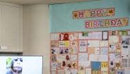 A TV screen showing the footages of the male Japanese macaque monkey named 'Punch' is pictured next to a wall with birthday messages for its upcoming one-year-old birthday, at Ichikawa City Zoo and Botanical Gardens in Ichikawa on July 24, 2026. (Photo by Philip Fong / AFP)