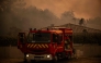 Firefighters spray water with a hose from the roof of a house during a wildfire near Lege Cap Ferret, southwestern France on July 23, 2026. (Photo by Julien De Rosa / AFP)
 