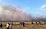Bystanders look on as fire and smoke billow across Castres-Mazamet aerodrome, near Labruguiere in south-western France on July 24, 2026. (Photo by Daniel ABELOUS / AFP)

