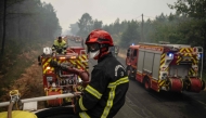 Firefighters operate from a column of firefighters vehicles near the town of Lacanau, in southwestern France on July 25, 2026. (Photo by Julien De Rosa / AFP)