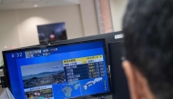 Reporters watch the news showing a large quake and possible one meter tsunami wave in Southern Japan, from an office in Tokyo on July 28, 2026. Photo by Andrew Caballero-Reynolds/ AFP