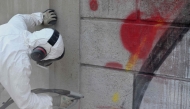 Valerio Tuveri works to erase graffiti from one of the external walls of Villa Sciarra in Rome on July 27, 2026. (Photo by Alberto Pizzoli / AFP)