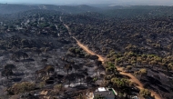 his general aerial view taken with a drone shows a burnt forest in Pelayos de la Presa, 65 kilometres west of Madrid, following devastating wildfires in the region on July 30, 2026.  (Photo by OSCAR DEL POZO / AFP)