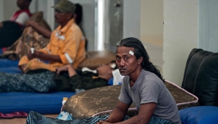 Survivors of the ferry fire recover at Tanjung Perak port in Surabaya on August 3, 2026, a day after the disaster that killed at least five people and prompted many to jump from the vessel into the sea. (Photo by JUNI KRISWANTO / AFP)