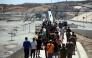 A group of migrants approach the border post to make their way back to Morocco, escorted by Spanish infantry soldiers, in the Spain's north African enclave of Ceuta, on August 2, 2026. Photo by Henry NICHOLLS / AFP