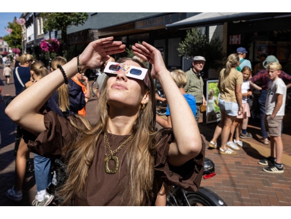 A woman wears eclipse glasses in Almelo, eastern Netherlands on August 11, 2026 on the eve of a partial solar eclipse. Photo by Vincent Jannink / ANP / AFP