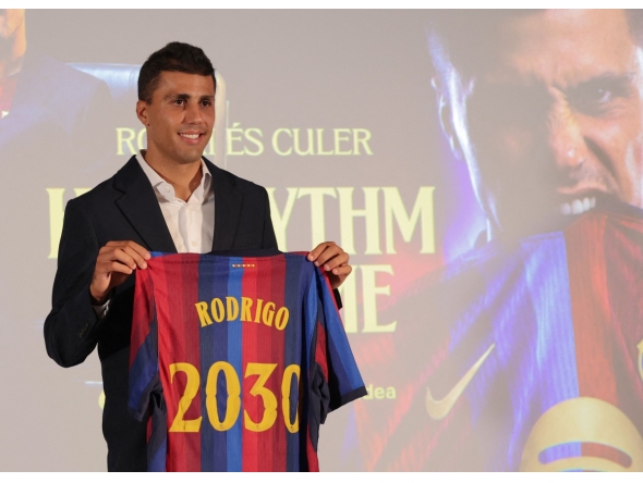 Spanish international footballer Rodri poses with a jersey bearing his name during his official presentation as FC Barcelona's new player on August 18, 2026 in Barcelona. (Photo by Lluis GENE / AFP)