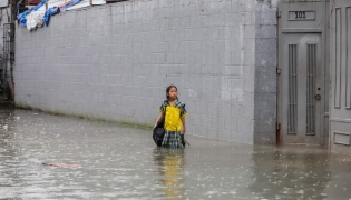 A student stands in floodwater in Quezon City, the Philippines, on Aug. 17, 2026. (Xinhua/Rouelle Umali)