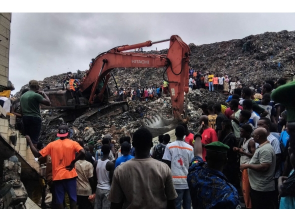 Residents and rescuers use an excavator to search for bodies after a landslide struck the Dar es Salaam dumpsite overnight in Conakry on August 23, 2026.