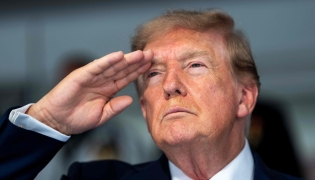 US President Donald Trump salutes during the national anthem at the start of the race, during the Freedom 250 Grand Prix Race on the streets of Washington, DC, on August 23, 2026.(Photo by Doug MILLS / AFP)