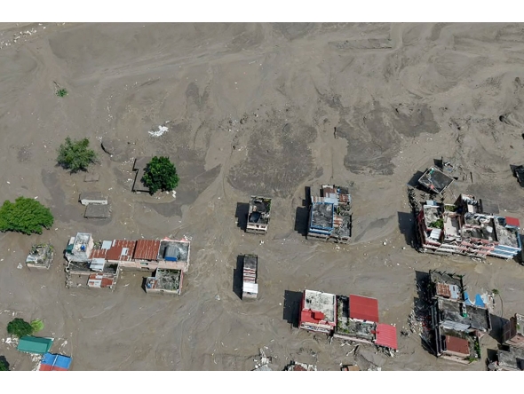 Houses lie partially submerged in muddy water along a riverside after flash floods at Trishuli Bazar in Nepal's Nuwakot district on August 26, 2026. (Photo by Prabin RANABHAT / AFP)