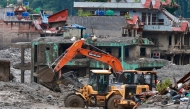Workers use excavators to clear the mud at the Dhunge Bazaar in Nepal's Nuwakot district on August 29, 2026 after flash floods and landslides hit the Nepal-Tibet border. (Photo by PRABIN RANABHAT / AFP)