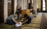 This photo taken on June 6, 2026 shows Kinan Abou Haikal (L), the elder brother of seven-month-old baby Sam Fahd Abou Haikal, sitting next to his body at the Abou Heisheh Mosque in Hebron, in the Israeli-occupied West Bank. (Photo by JOHN WESSELS / AFP)