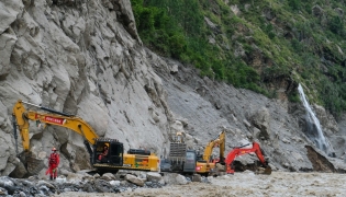 Workers use excavators to clear debris and rebuild the mudslide-damaged road which leads to Gyirong Port in Gyirong County, in China's western Tibet region on August 30, 2026. Photo by CNS / AFP