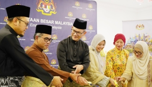 Ambassador of Malaysia H E Faizal Razali with officials and community members cutting the cake.