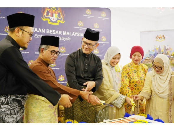 Ambassador of Malaysia H E Faizal Razali with officials and community members cutting the cake.