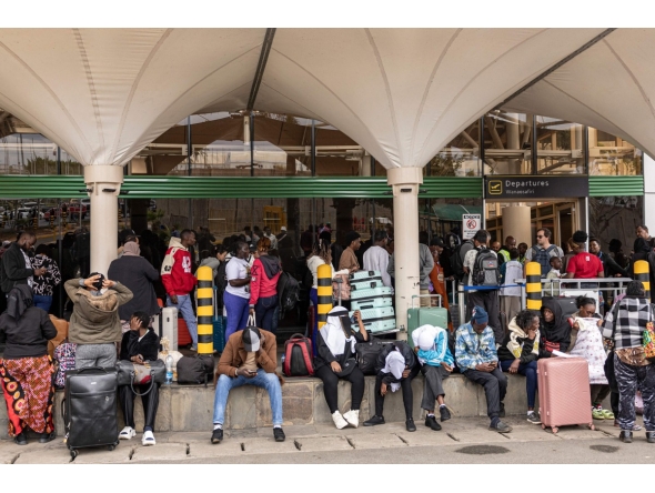 Stranded passengers sit on the pavement as they wait with their luggage by the departure terminal of the Jomo Kenyatta International Airport (JKIA) after staff from the Kenya Airports Authority (KAA) and Kenya Civil Aviation Authority (KCAA) airport workers' go-slow strike action continued into its second day, in Nairobi, on August 31, 2026. Photo by SIMON MAINA / AFP