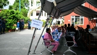 Family members wait to register their information with police personnel to give blood samples for DNA testing to help identify their missing relatives after flash floods, at the Nepal Police Hospital in Kathmandu on September 3, 2026.  (Photo by Manan VATSYAYANA / AFP)
 