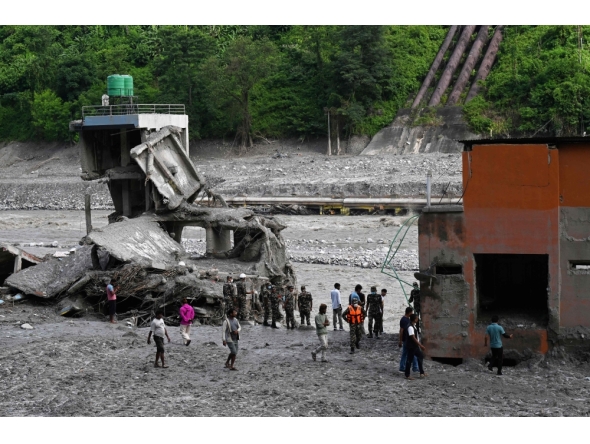 Security and relief personnel stand along the Trishuli riverbank in the aftermath of flash floods at Trishuli Bazar in Nepal's Nuwakot district on September 5, 2026. (Photo by Prakash MATHEMA / AFP)