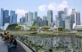 People sit next to a pond outside ArtScience museum at Marina bay in Singapore on September 8, 2026. (Photo by Roslan RAHMAN / AFP)