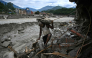 A man carrying his belongings walks past a damaged house in the aftermath of flash floods at Trishuli in Nepal's Nuwakot district on September 11, 2026. (Photo by Prakash MATHEMA / AFP)