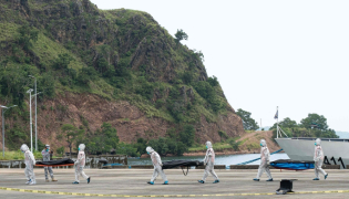 Philippine coast Guard personnel in protective suit carry body bags of victims from a ferry fire blaze to a tent for identification at the port of Borac in Coron, Palawan province on September 12, 2026. (Photo by Ron Lopez / AFP)